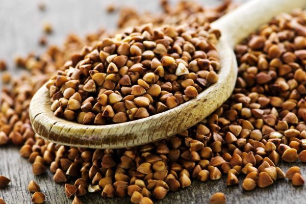 Buckwheat seeds on wooden spoon in closeup