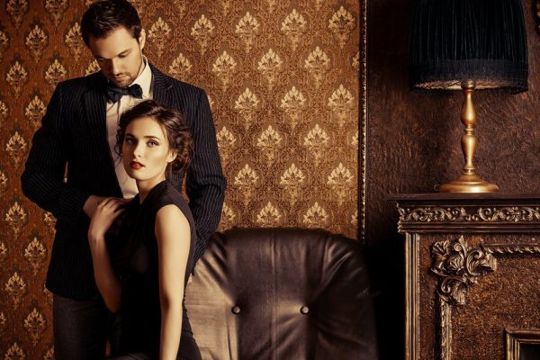 Beautiful man and woman in elegant evening clothes in classic vintage apartments. Glamour, fashion. Love concept.