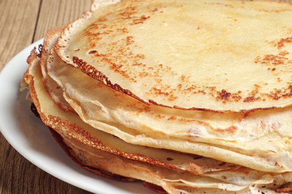 Stack of pancakes on wooden table closeup