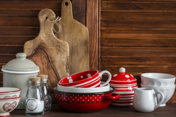 Kitchen still life. Vintage crockery - jar of flour, ceramic bowls, pan, enamelled  jar,  gravy boat. On a dark brown wooden table. Vintage and rustic style