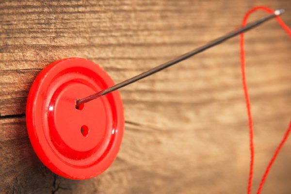 needle and a button on the board