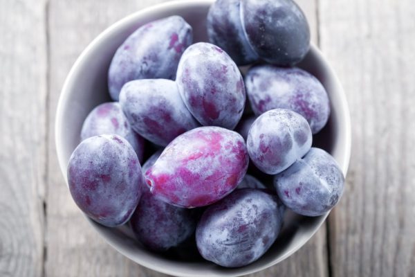 Fresh and ripe Plums on a wooden table