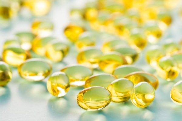 Omega 3 gel capsules. Fish oil pills. Healthy omega-3 on blue background.