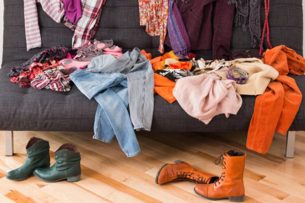 What to wear? Messy colorful clothing on a sofa.