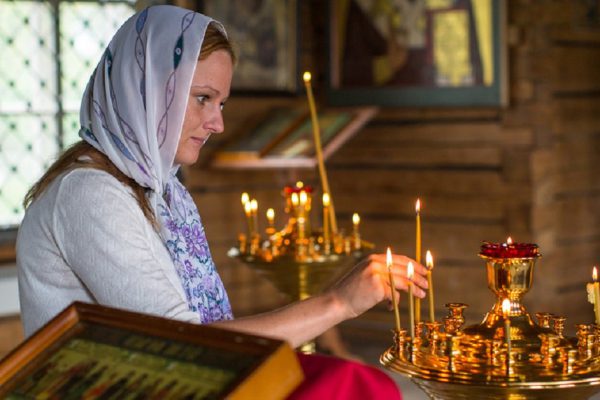 SOGINICY, RUSSIA - JUL 30, 2016: Unidentified parishioner of Church of Nichola. Church of St. Nicholas at Soginicy, the only surviving sample of a steepled Church prionezhskiy school, 1696 built.