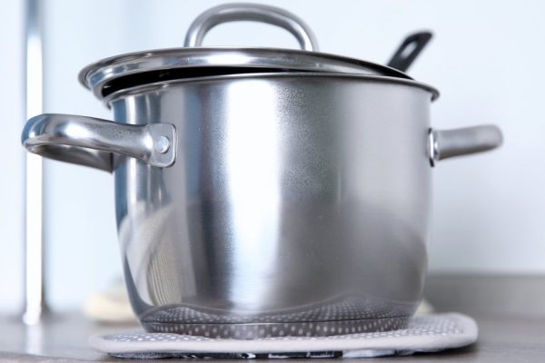 Stainless saucepan on grey kitchen table, closeup