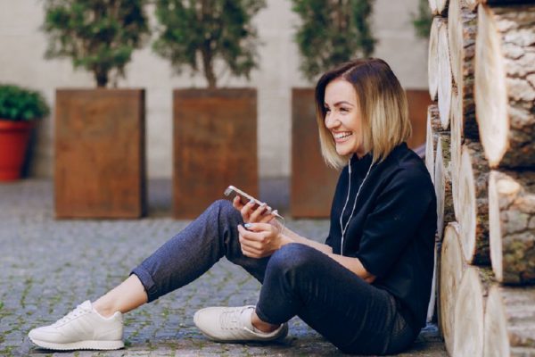 young beautiful girl using the phone sitting smiling