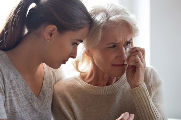 Loving adult female hug comfort caress crying elderly mother wipe tears use paper tissue, show support and care, depressed desperate mom and daughter feel sad unhappy mourning for family loss