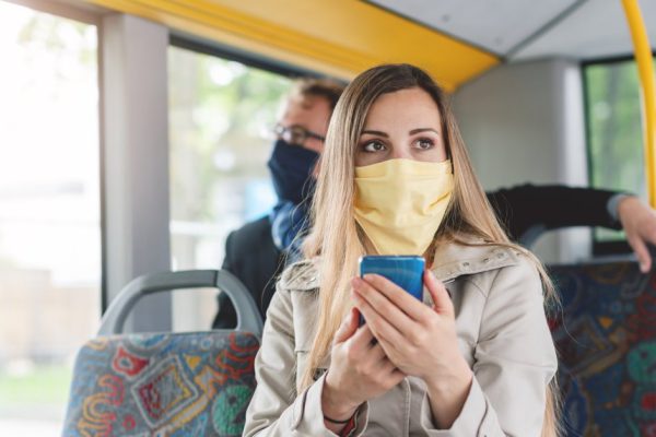 People wearing masks in the bus using public transport keeping proper distance