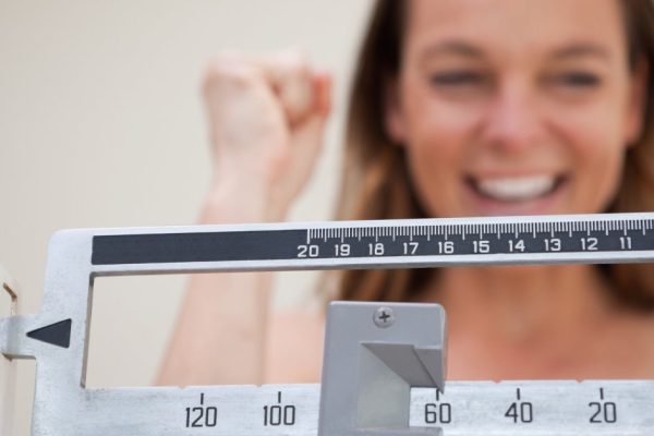 Scale showing weight loss to smiling woman