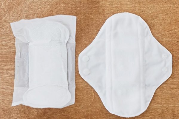 Reusable eco pad and single use toxic pad for menstrual days, flat lay. Chose feminine  healthy and eco friendly pads against plastic pads. Stop plastic pollution. Zero waste lifestyle