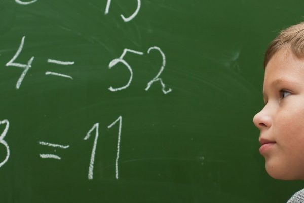 The schoolboy at a lesson of mathematics at a school board