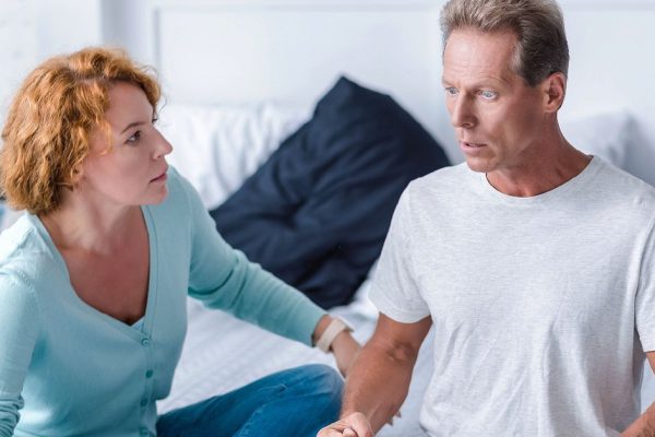 I hitting you now. Furious husband going to hit his wife while sitting on the bed and arguing