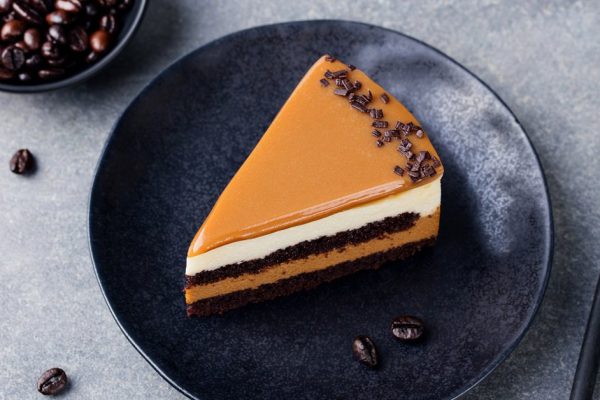Caramel cake, mousse dessert on a plate. Grey stone background. Top view