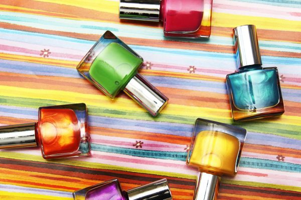 Colour vials of nail polish on a colour background