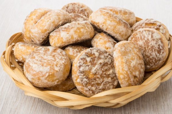 Heap of honey-cake in wicker basket on wooden table