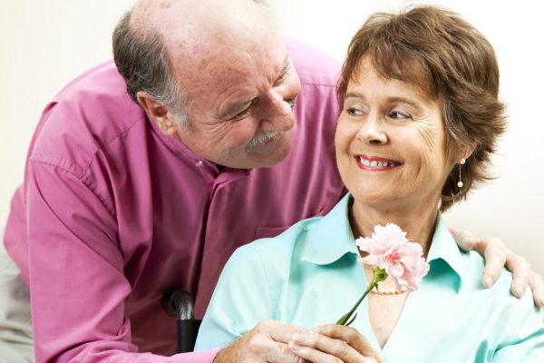 Senior man gives his beautiful wife a flower.