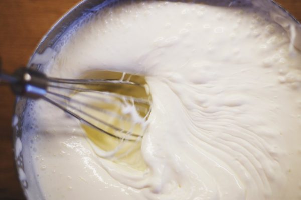 cream is whipped with a mixer in a bowl