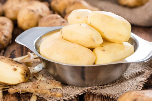 Portion of peeled Potatoes on old wooden table