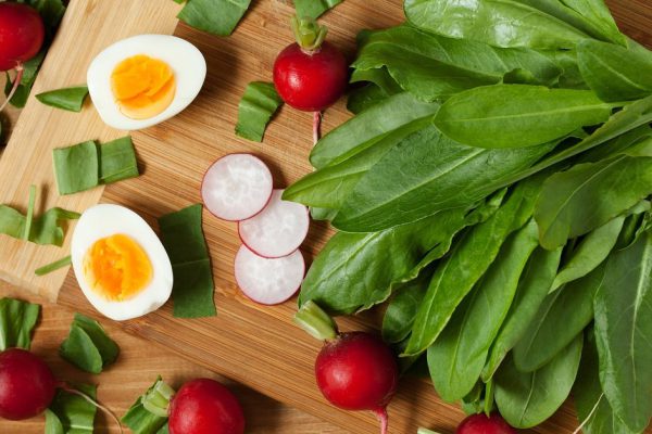 Healthy spring vegetables, sorrel, radish and eggs on wooden table. Super food nutrition.