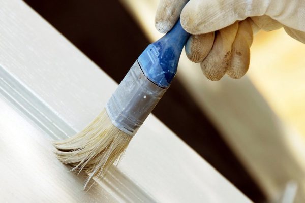 painting wooden door in white color by blue brush