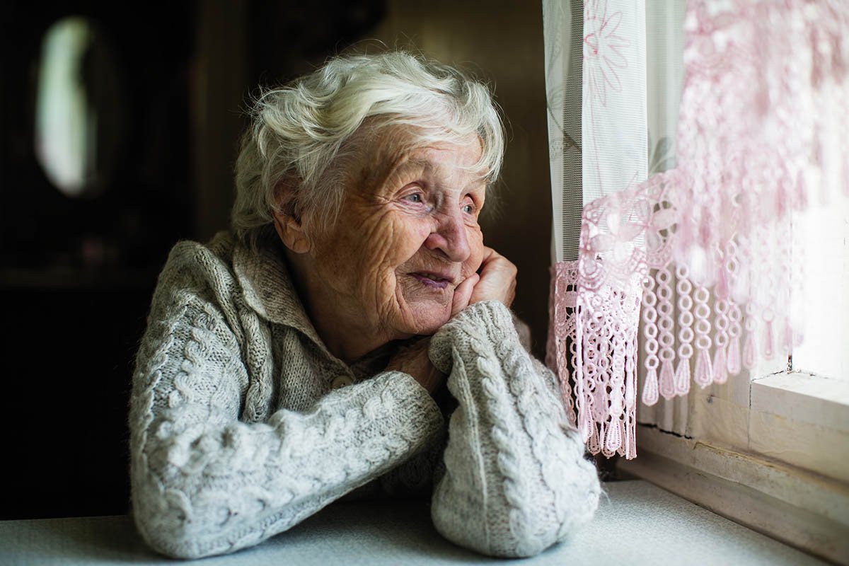 добрая старая женщина смотрит в окно