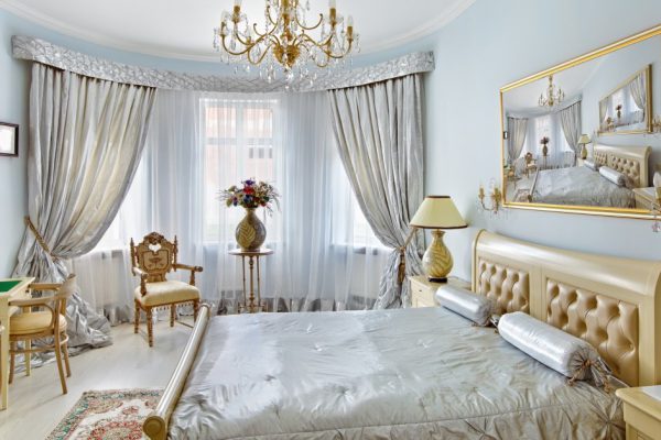 Classic style luxury bedroom interior in blue colors with boudoir and window