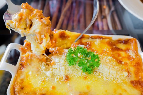 traditional lasagna made with minced beef bolognese sauce topped with basil leafs