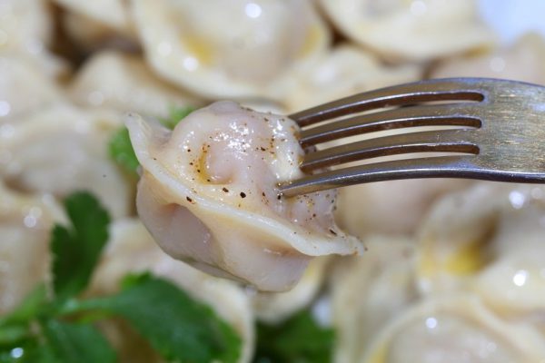 Pelmeni with sour cream, the butter ground by pepper and fresh parsley