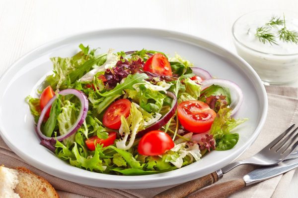 Plate of fresh salad with cherry tomatoes and onions