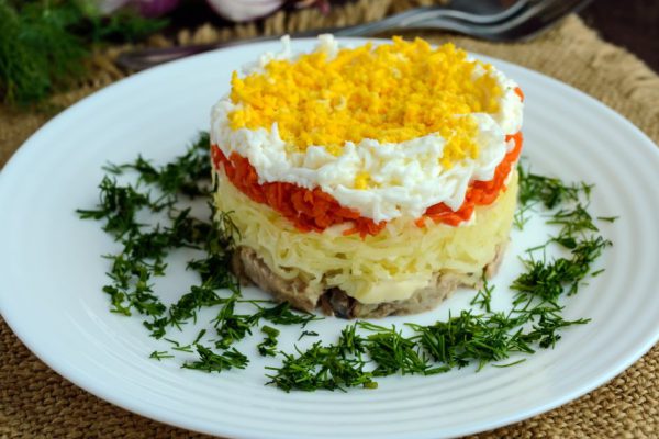 Easy Diet salad layers in the shape of a circle (tuna in oil, boiled potatoes, carrots, eggs). Alternative Slavonic traditional dish "Mimosa".
