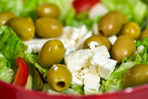 Greek salad with iceberg lettuce, olives, feta cheese and condiments
