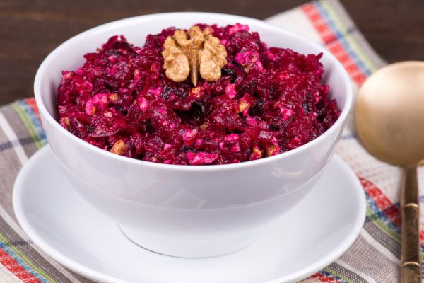 Fresh salad with beet and walnuts on white plate