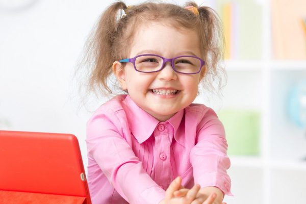kid with tablet PC in glasses as early education concept