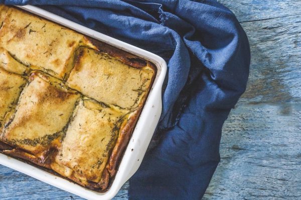 baked stuffed crepes on a blue background and an old blue napkin top view