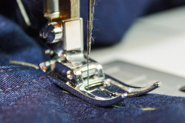 Sewing machine and jeans fabric. Focus on the needle.