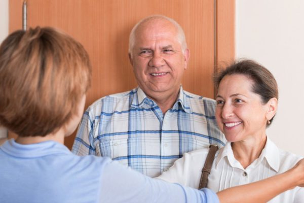 Woman meeting mature friends at the door
