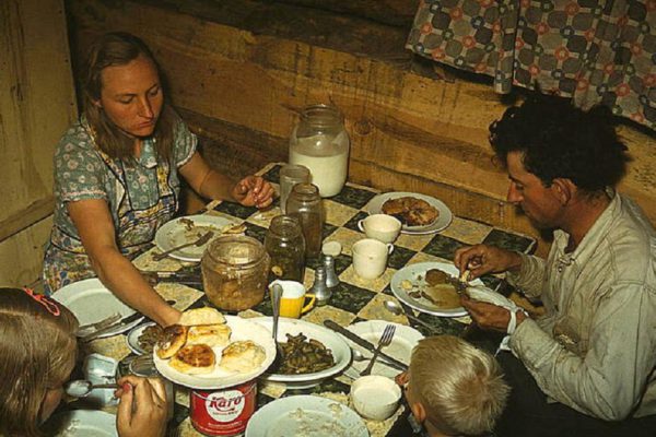The Faro Caudill family eating dinner in their dugout. Pie Town, New Mexico, October 1940. Reproduction from color slide. Photo by Russell Lee. Prints and Photographs Division, Library of Congress
