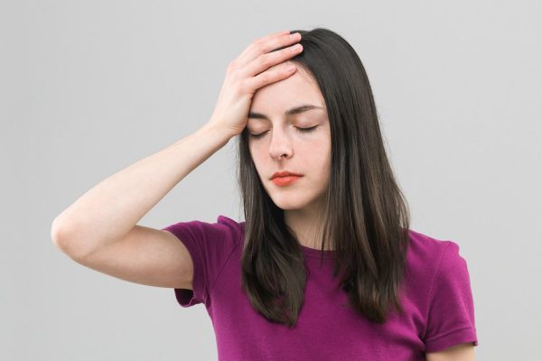 portrait of young caucasian woman suffering from headache