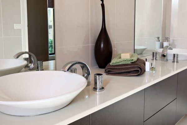Modern bathroom, with double round sinks.  Earthy tones of beige and brown.