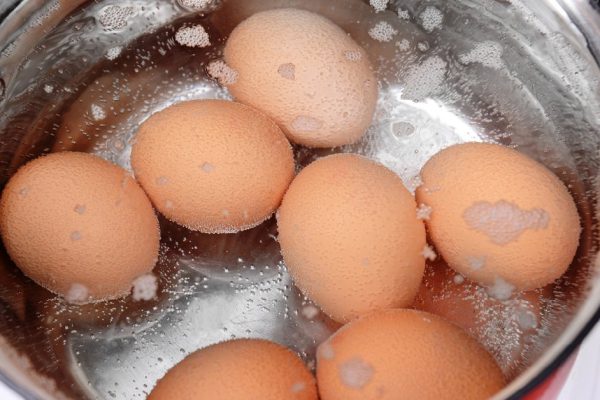 Eggs in boiling water in pan on electric hob