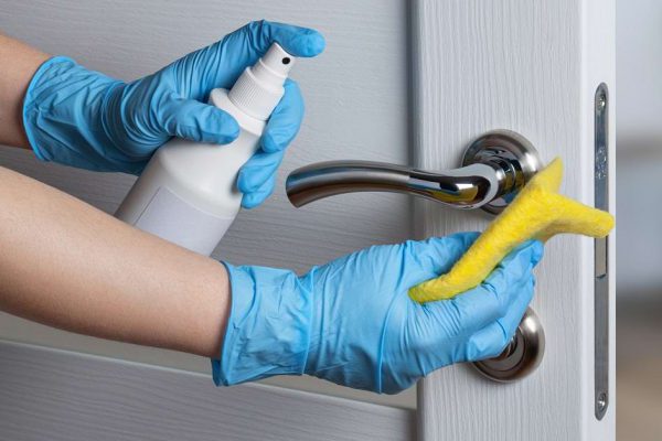 Cleaning door handles with an antiseptic during a viral epidemic