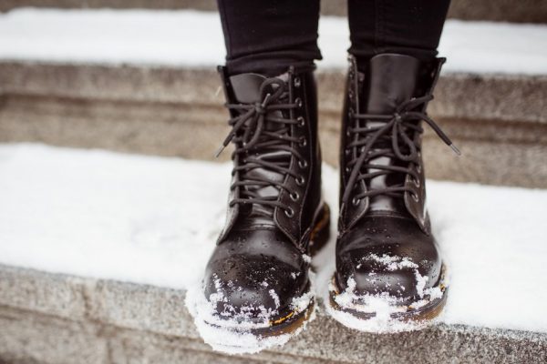 Black women's shoes on the stone steps covered by snow in the winter.