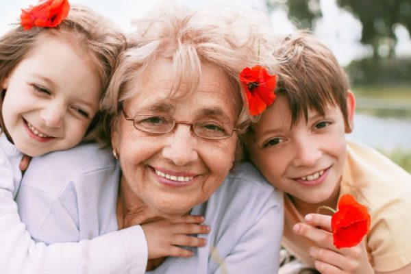 Closeup summer portrait of happy grandmother with grandchildren outdoors