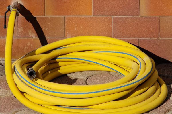 Yellow Garden hose connected to faucet