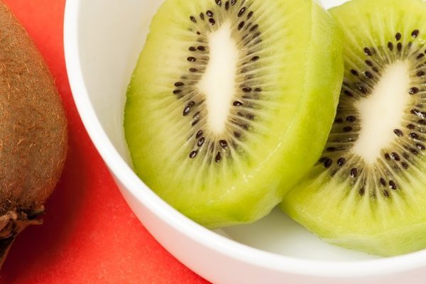 graphic composition with kiwi on red background