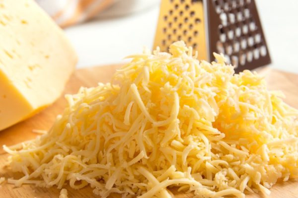 Grated cheese on wooden cutting board