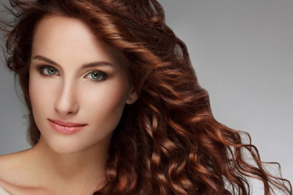 Red Hair. Beautiful Woman with Curly Long Hair. High quality image.