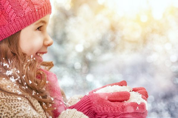 happy child girl plaing on a snowy winter walk