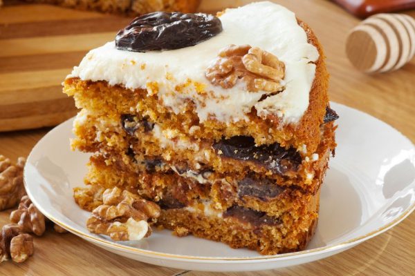 piece of honey cake with plum and walnut on kitchen table